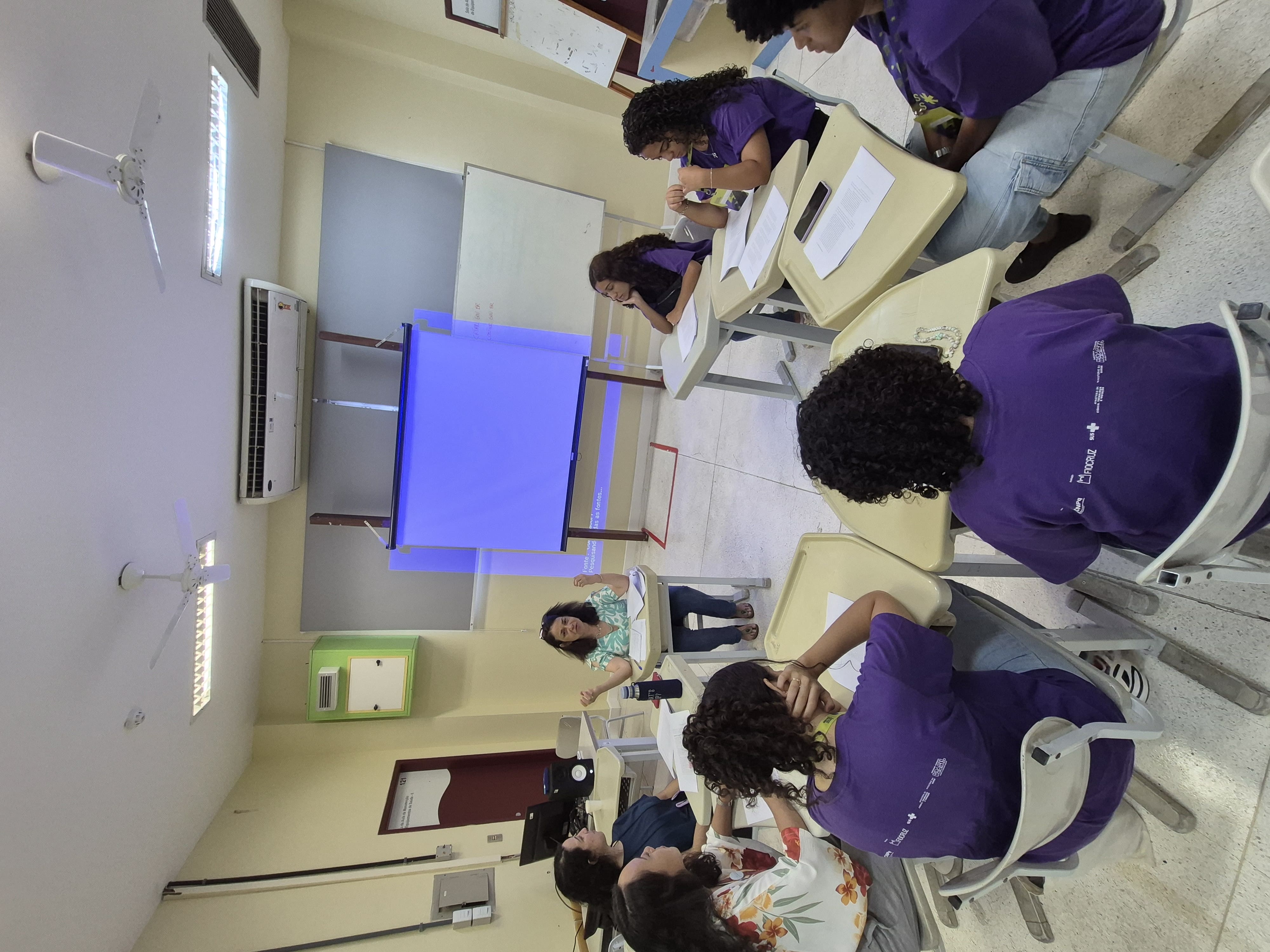 pesquisadoras e meninas sentadas em roda em conversa em sala de aula.