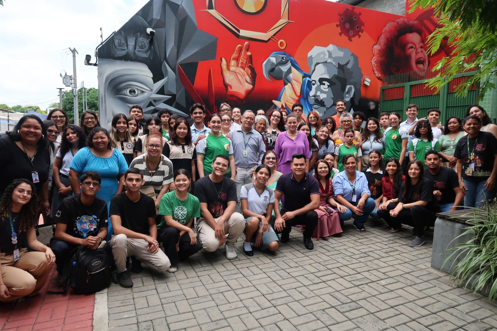Equipe de Manaus e Rio com estudantes e orientadores na frente de muro com arte de rua.