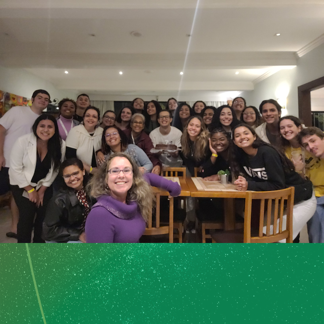 estudantes e equipe posam pra foto no espaço de convivência do hotel.