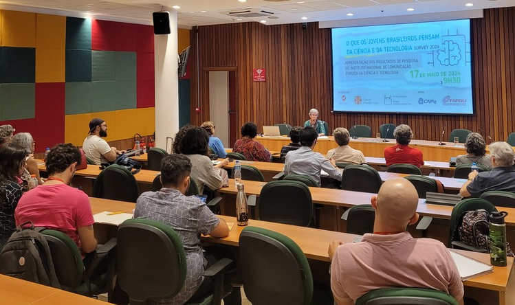 várias pessoas num auditório assistindo a uma apresentação.