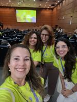 Quatro mulheres da Escola Politécnica de Saúde Joaquim Venâncio posam para foto no auditório do evento.