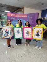 Foto com quatro jovens pesquisadoras segurando cada uma um cartaz com a foto de cientista mulher que é reconhecida pela sociedade.